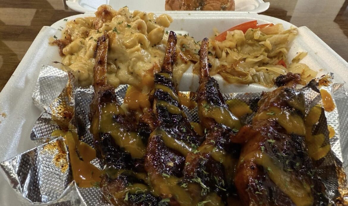 Glazed grilled meat skewers served in a foil takeout container.