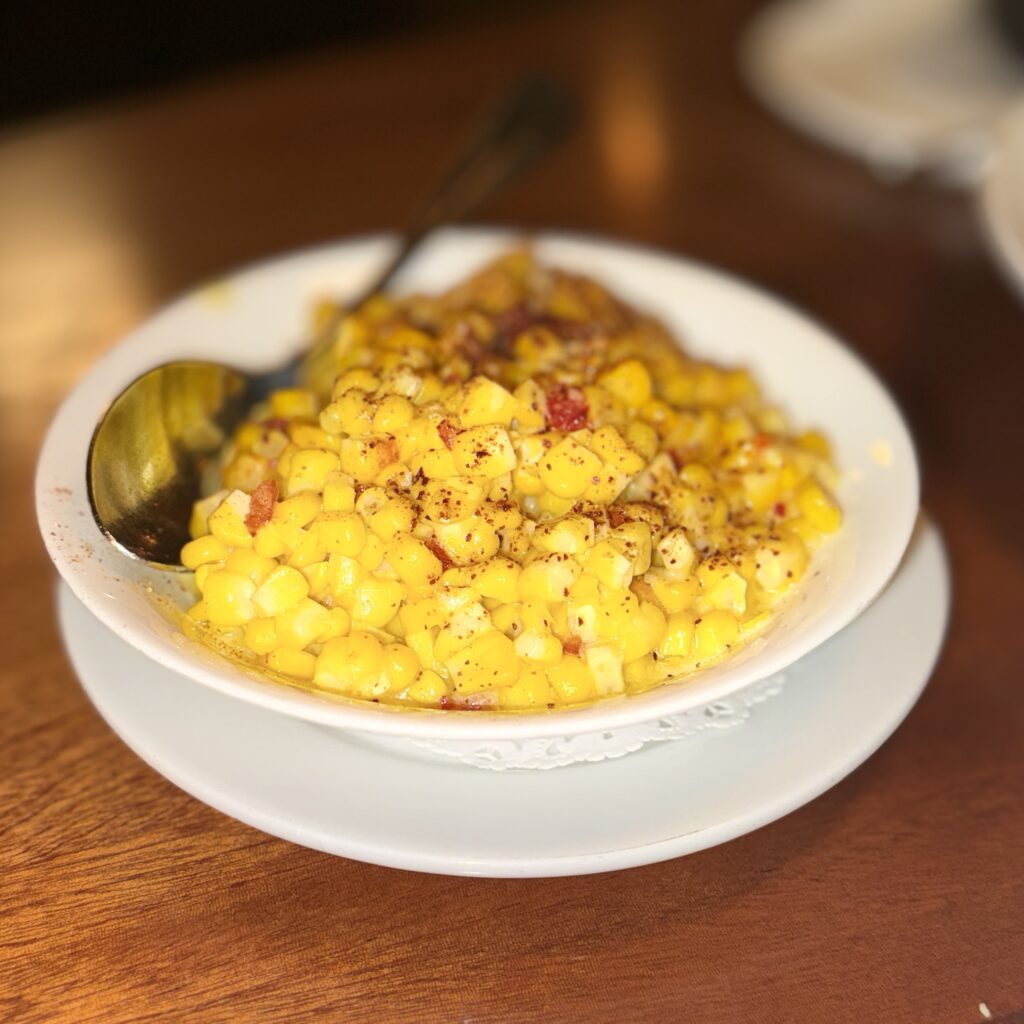 A bowl of Somerville's buttered corn with diced pickled fresno chiles and a dusting of espelette pepper.